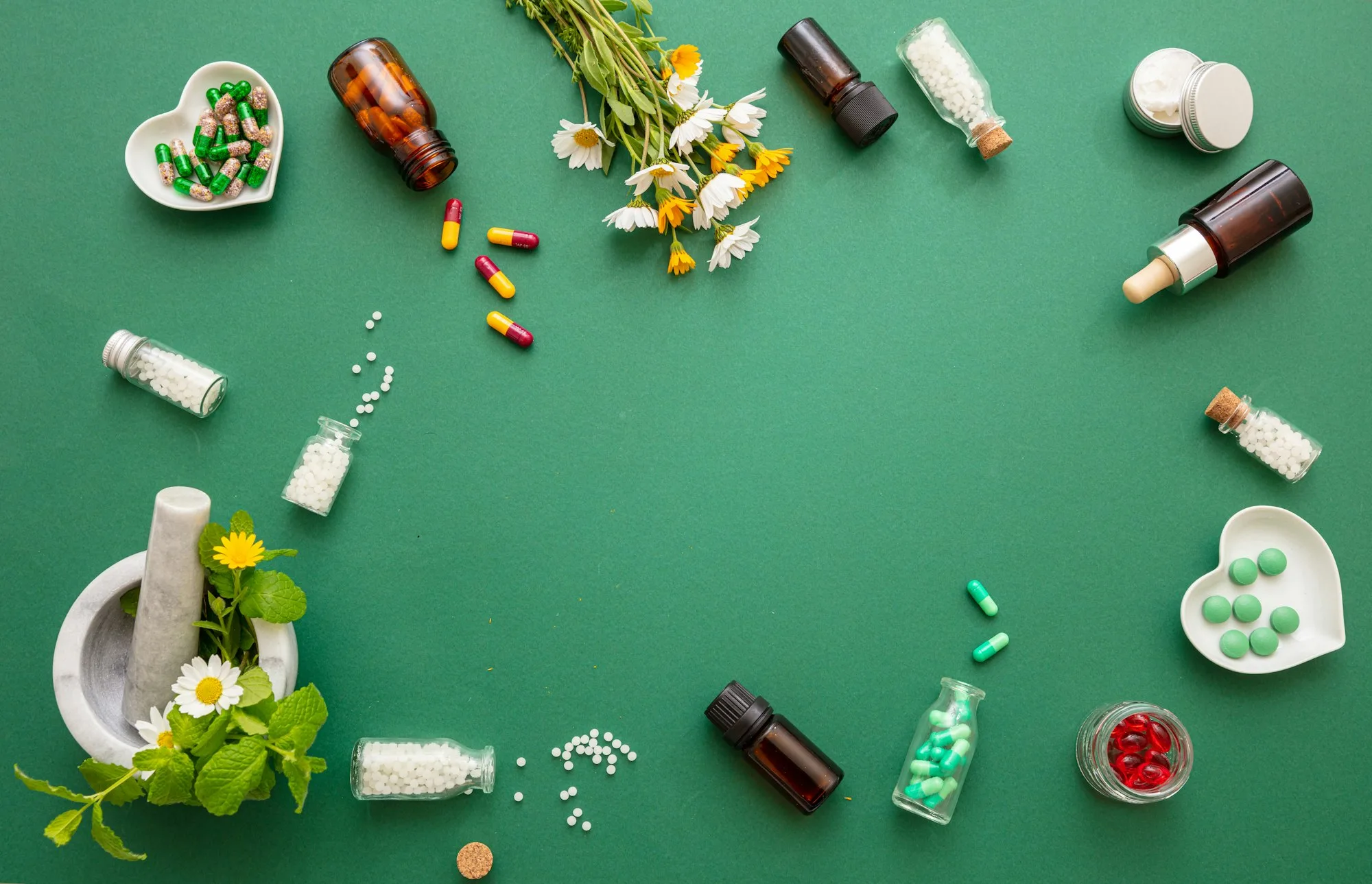 Homeopathy, globules and herbs on green background, Metagenics south Africa, homeopathy south africa